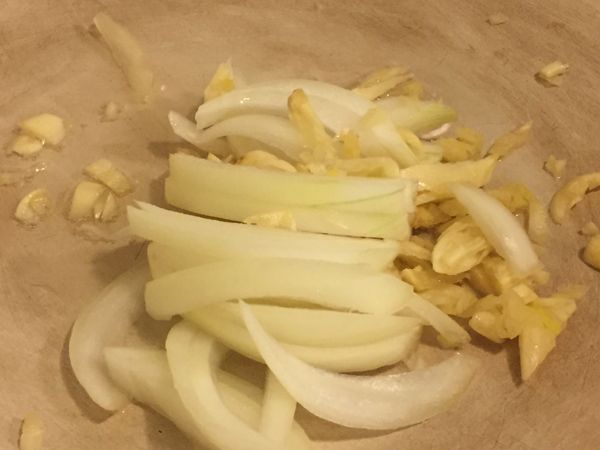 起ㄧ油鍋加上一點油、油不用多，因為鴨皮本身有油脂，加入大量的洋蔥絲及蒜末炒香