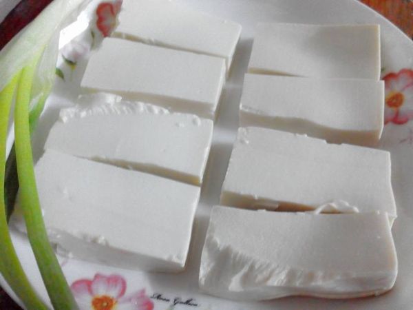 將板豆腐橫切對半，再直刀對切