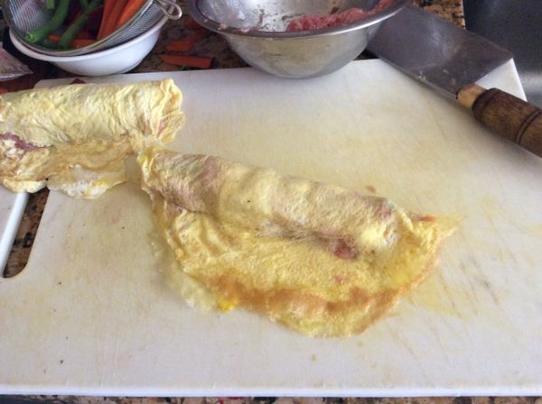 然後對折，肉餡在中間，兩端蛋皮合攏即可。