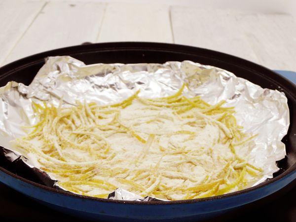 將錫箔紙放一張後放入鍋中麵粉、糖、柚子皮放入錫箔紙中