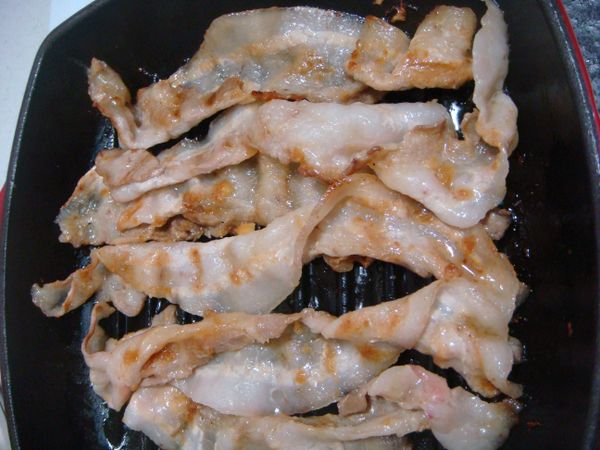 醃好的五花肉片，放入鍋中煎熟