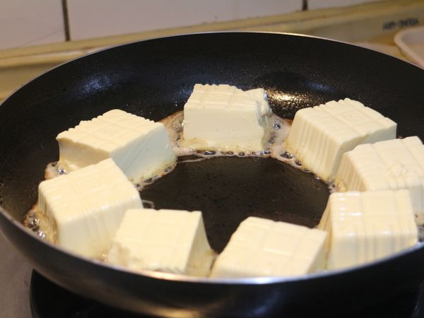 蛋豆腐瀝乾，切成4～6塊。以中火熱鍋和少許植物油，放入豆腐，轉小火煎至表面微焦。油要夠熱以防豆腐沾鍋，翻面時注意勿讓豆腐破碎。