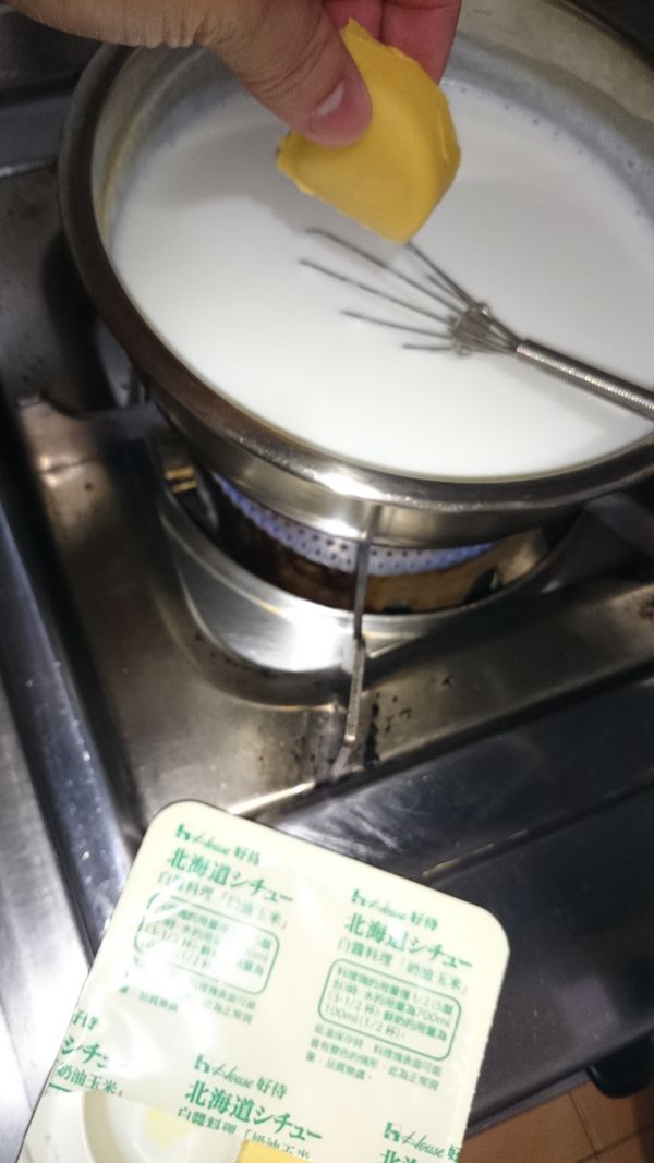 等到鮮奶白飯微滾(不可大滾，會沾鍋)，加入一小盒內的1/4小塊奶油湯塊，一樣保持攪拌動作直到奶油湯塊溶化，就可離火~