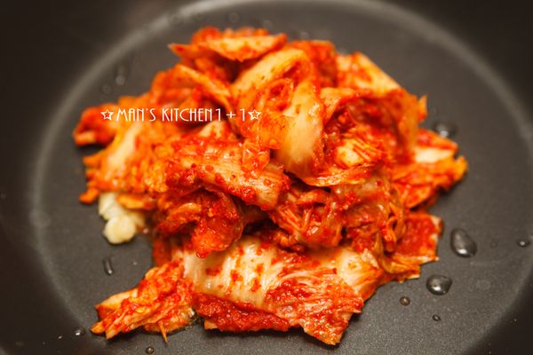 起油鍋，將大蒜和洋蔥下鍋爆香後加入泡菜炒香。