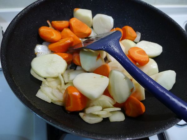 接著就可以將馬鈴薯和紅蘿蔔也下鍋拌炒，只要炒到每面都有接觸到油