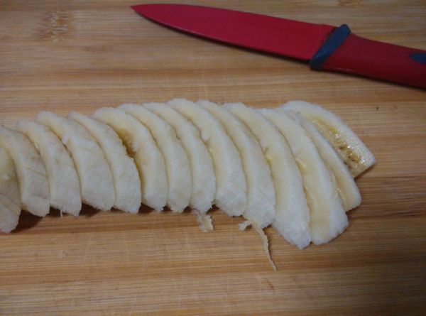 在烤土司時，取香蕉一根，剝去外皮，斜切成薄片備用。