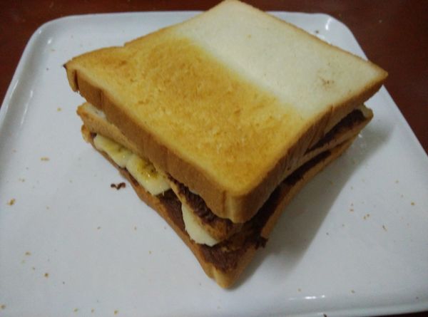 將土司重疊好，使用麵包刀切成2塊。