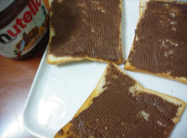 將土司抹上巧克力醬。