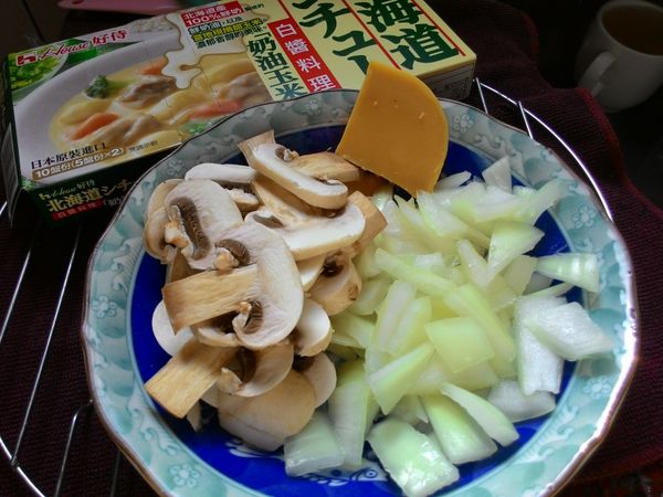 蘑菇切片、洋蔥切丁，好侍北海道白醬奶油玉米內含兩盒，取出其中一盒，切1/4小塊