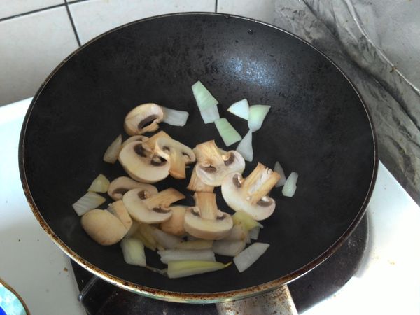 油熱之後，依序放進蘑菇、洋蔥拌炒