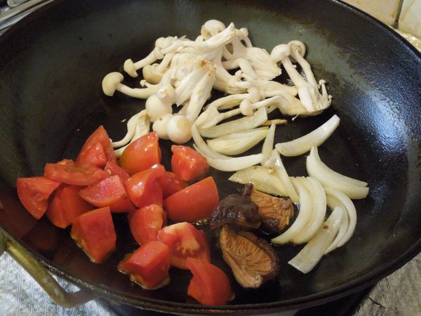 原鍋煎香洋蔥後,依序放入美白菇、番茄塊和泡水擰乾的香菇,煎到蔬菜變軟。