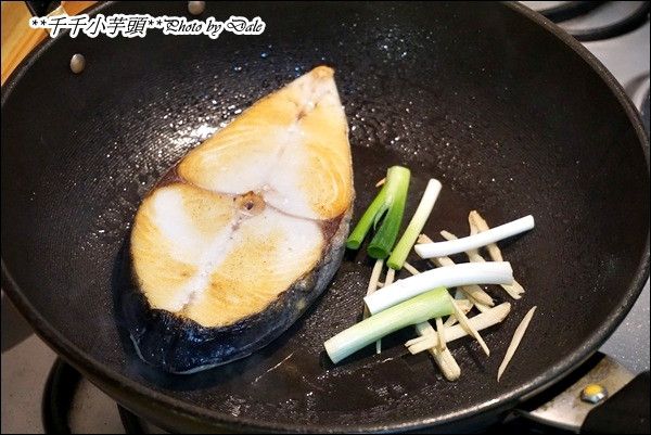 翻面後利用鍋邊將薑絲及蔥白段稍稍爆香