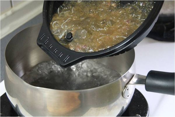 將麻油雞麵線拆開後取出雞腿與麵線等，將麻油雞湯倒入鍋中加熱。