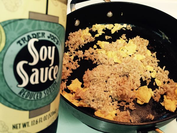 此時，倒入些許醬油，人夫們，不需要用什麼量杯，就倒在炒飯用的杓子上一點點，讓醬油慢慢漂漂亮亮地滑入飯與蛋中，此時，就可以快手炒飯了