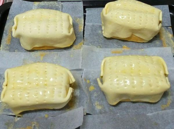 將酥皮舖在放涼後之蛋糕吐司，酥皮表面，用叉子戳洞，刷蛋液，烤溫上火220下火0  20-25分(酥皮要全澎起)