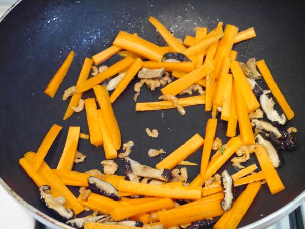 熱鍋，下2大匙油，先爆香蝦米，然後放入香菇絲、紅蘿蔔，肉絲，炒約1分鐘後沿鍋邊加入1.5大匙醬油嗆香，然後加入100cc泡香菇的香菇水