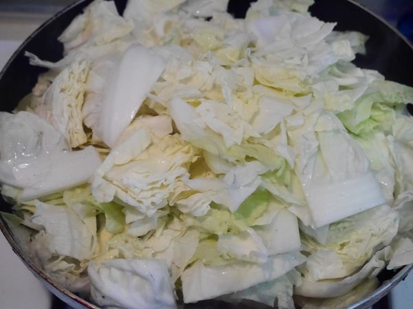 將大白菜放入後蓋鍋，不需翻炒，煮到白菜出水後再翻炒，只要將材料拌勻即可，整個鍋大滾且白菜出水後，就可以轉中小火慢煮了。