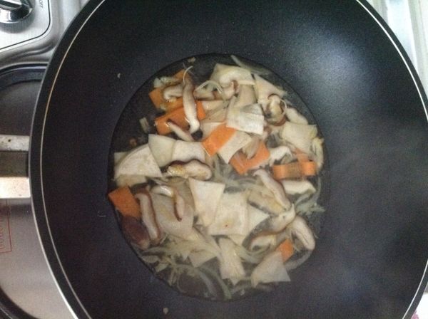 待香腸煎至焦香時取出，此時倒入菇菇，拌炒一下加入水燒煮。