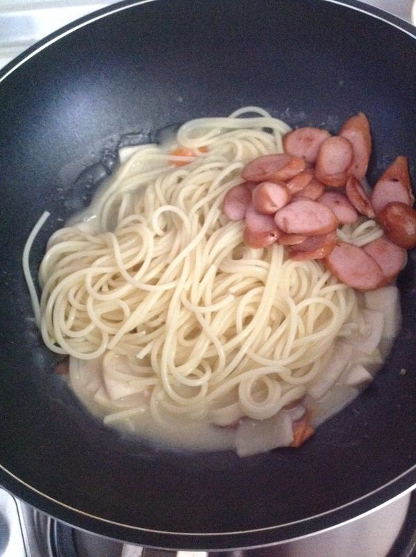 此時義大利麵也好了，將義大利麵和香腸倒入不粘鍋，開小火拌炒均勻即可盛起。