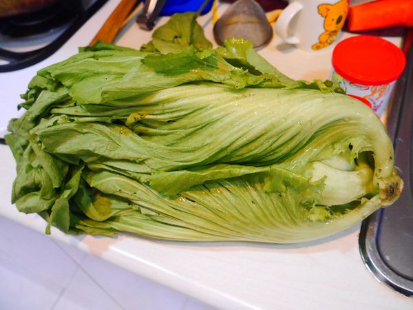 備料，婆婆種的芥菜又大又漂亮，可能是因為種在山上所以比較嫩又不苦澀。芥菜一葉一葉剝下後洗淨先切塊，梗跟葉分開，蛤蠣吐沙洗淨備用，雞腿肉川燙備用