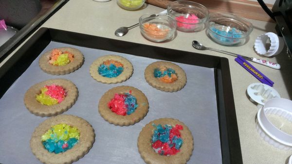 取出步驟8烤盤，小心不要燙傷~烤過八分鐘的餅乾顏色變淡，填入敲碎的糖果，可以依自己喜好配色，糖果量約與餅乾表面齊平，不需要太滿