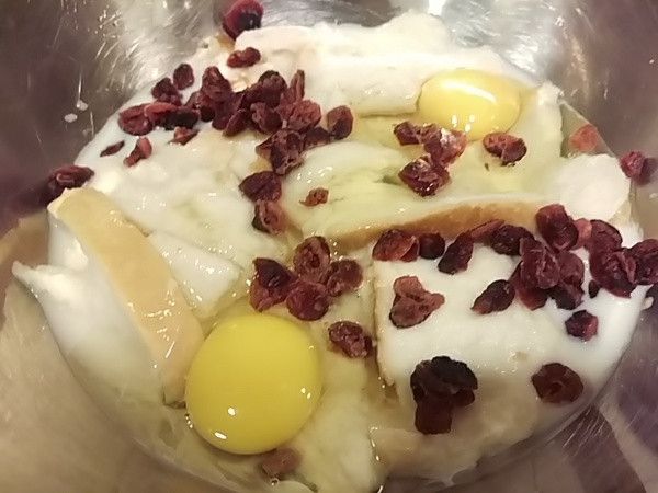 待吐司吸足鮮奶後再放入兩顆全蛋及蔓越梅乾