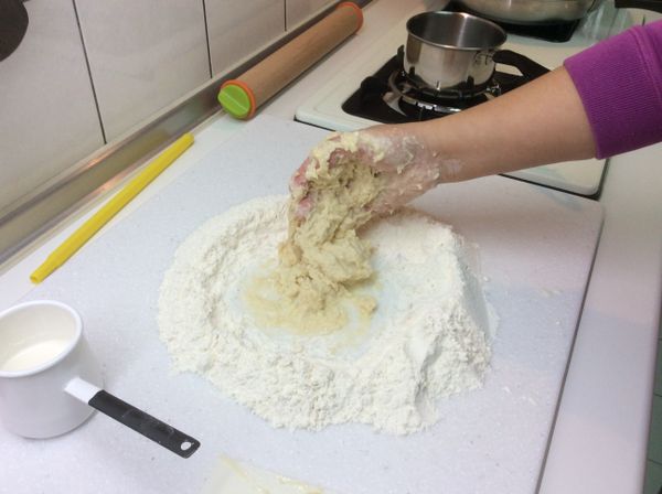 中筋麵粉和酵母粉用刮板先拌勻後，圍成麵粉牆中間放置切小塊的老麵團、砂糖、鹽巴，倒入60cc左右的溫牛奶，先將老麵團、砂糖、鹽巴和勻