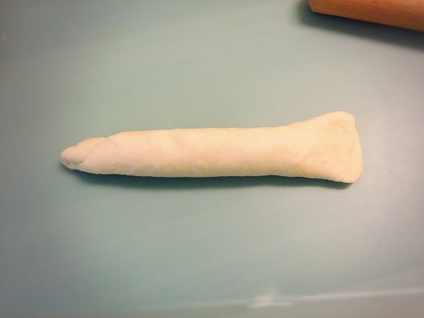 由上邊往下捲長條，邊邊黏緊密，兩端留一邊壓成傘狀(如圖形狀)