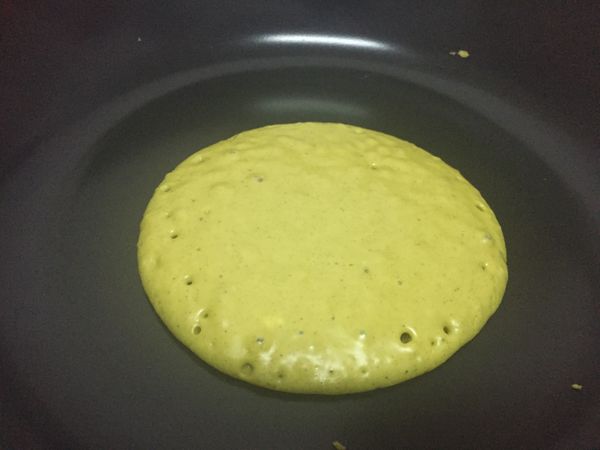 平底鍋遇熱，以紙巾沾一點奶油擦拭鍋面，舀一匙麵糊至鍋內並蓋鍋蓋，看到鬆餅表面產生氣泡，就可以翻面