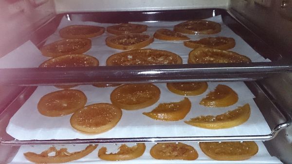 先準備烤箱，將烤箱用120度預熱15~20分，在烤盤鋪上烘培紙後再將橙片放上烤盤入烤箱用110度低溫烘烤約50~60分，期間要注意不要烤焦了!因為只是要將橙片烘乾至不黏手，如果烤焦吃起來會很硬!