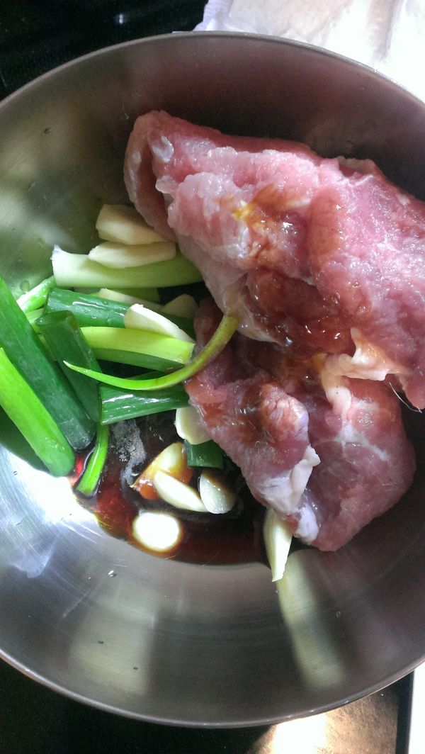 里肌肉請店家拍一拍，回來後洗淨，並輕輕擠掉多餘水份(洗淨的原因是衛生乾淨考量)。將蔥段丶蒜片丶醬油丶醬油膏丶白芝麻油(用黑麻油也行)丶胡椒鹽和肉片以手揉均