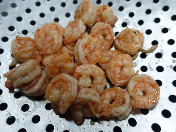 下油熱鍋，將蝦仁煎至大約八分熟，取出