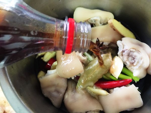 電鍋內鍋放入川燙好的豬腳、可樂、醬油、八角、月桂葉、蔥、蒜頭、薑