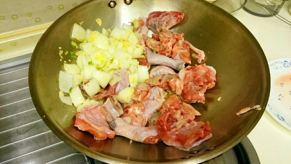 放入五德雞塊（雞皮向下，爆出雞皮的油）再炒匀