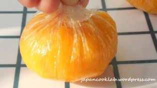 提起保鮮膜的四角,  向內包裹小球,  把頂部的保鮮膜用一拉,  製造金團的摺紋。