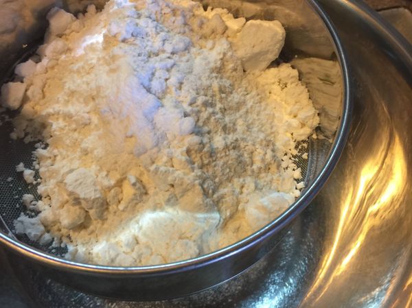 將低筋麵粉、泡打粉過篩，加入檸檬皮屑、鹽