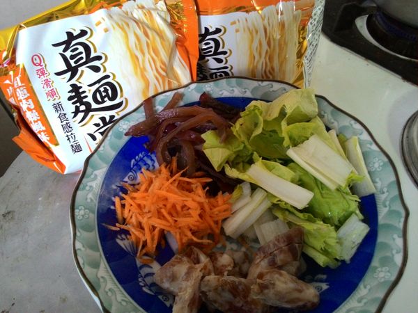 先將食材備妥：紅蘿蔔、木耳切絲，小白菜切小段、香腸切片。真麵堂1小包