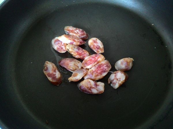 起鍋熱油，放入香腸。香腸會出油，油不用倒太多