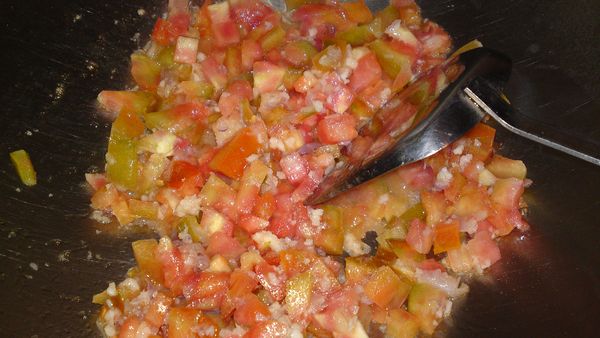 起油鍋，加[爆香料]炒香，加入蕃茄丁拌炒一下