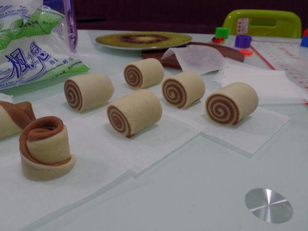 鬆弛完畢，各揉2-3分鐘 圖中有兩種不同顏色疊成 所以我再把麵團對切分成四份 各三桿三折  把空氣壓出，之後各桿成薄片  兩片重疊  再桿成薄片(自行衡量不用太薄，方便滾起即可)
切自行想要大小 孩子要吃我就切小一點 大約7-8等份 大人大約兩口！