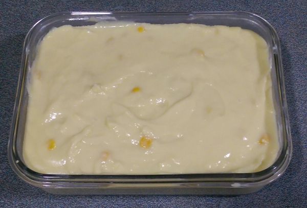 將椰香玉米雪花糊倒入玻璃保鮮盒中，用刮刀將表面稍微抹平後，室溫放涼後放入冰箱冷藏數小時，待整個凝固後取出切塊即可。(可在玉米雪花糕最上面鋪上一張烘焙紙，以防表面與空氣接觸而變硬)