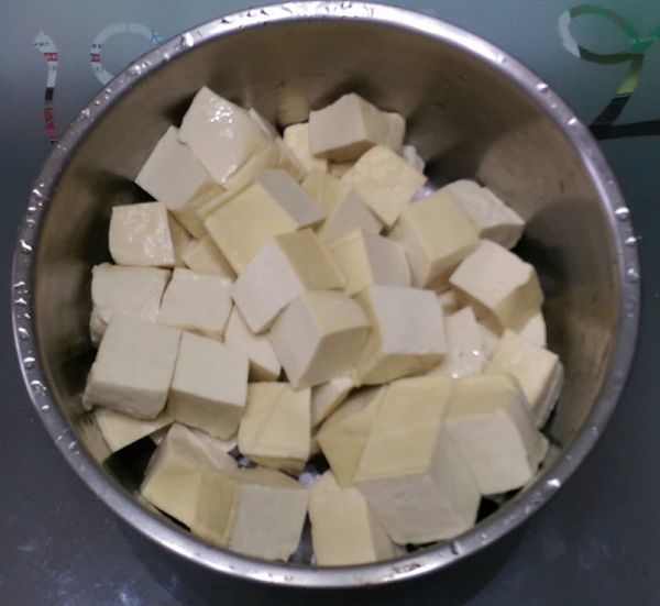 板豆腐泡水清先一下後瀝乾水份，並將其切成4小塊；百頁豆腐清洗一下，切成若干小塊。