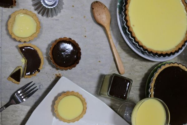 塔皮旁邊放涼。牛奶用小鍋子煮到旁邊冒小泡泡，轉小火慢慢加入布丁粉，等全部溶化就可以加入塔皮裡。要做巧克力口味的就再自行加入巧克力煮到巧克力融化就好!