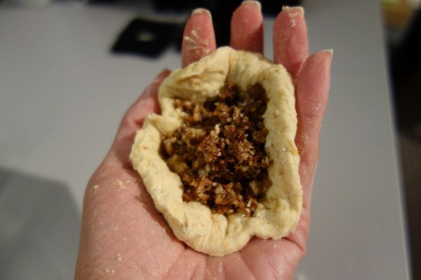 麵糰發酵好揉成一長條，切成六段，整成圓餅形狀(中間不要太薄才不會破掉，周邊可以壓薄一點因為收口會重疊)，將內餡放在中間包好收口，輕輕稍微壓成圓扁型。