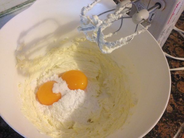 先把奶油放在一個小盆子裡如圖，用電動攪拌器打發奶油成乳白色，再下蛋黃，糖粉再打。