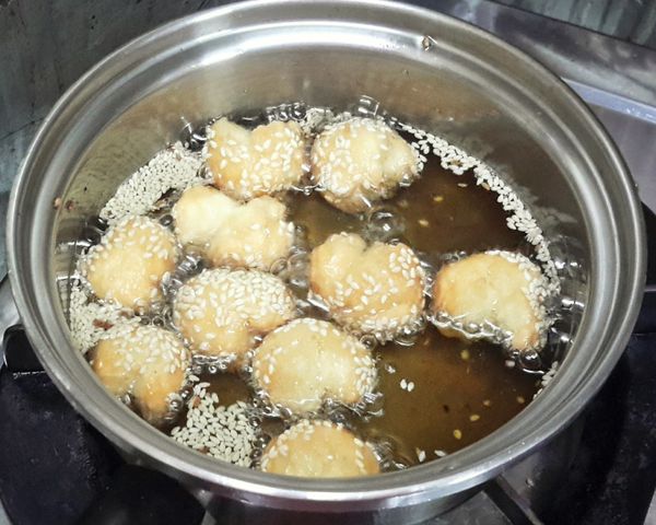 將開口笑放入熱油鍋內（約170度），然後轉小火炸至裂口出現（約3-4分鐘），然後轉中火再炸1-2分鐘至金黃色即成！