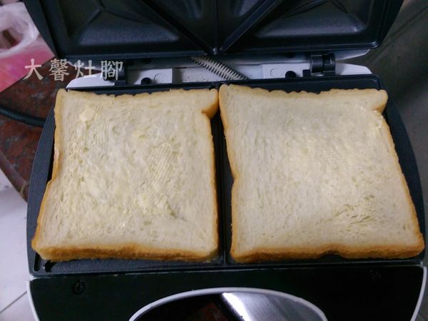 因為怕太乾，將二片土司放在三明治機上，先抹一層薄薄的奶油。