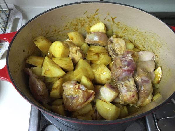 利用鍋裡殘餘的雞油炒洋蔥，洋蔥略微軟化，加入咖哩粉炒香，再加入魚露及糖拌炒，等糖融解後，再加入剛取出的雞腿肉跟馬鈴薯塊。