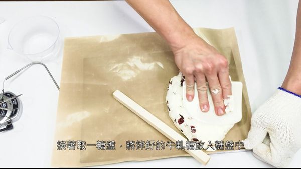 將拌勻的牛軋糖放置糖盤塑型