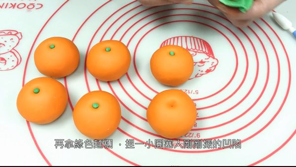 將綠色麵糰捏一紅豆大小，塞入凹洞內做蒂頭